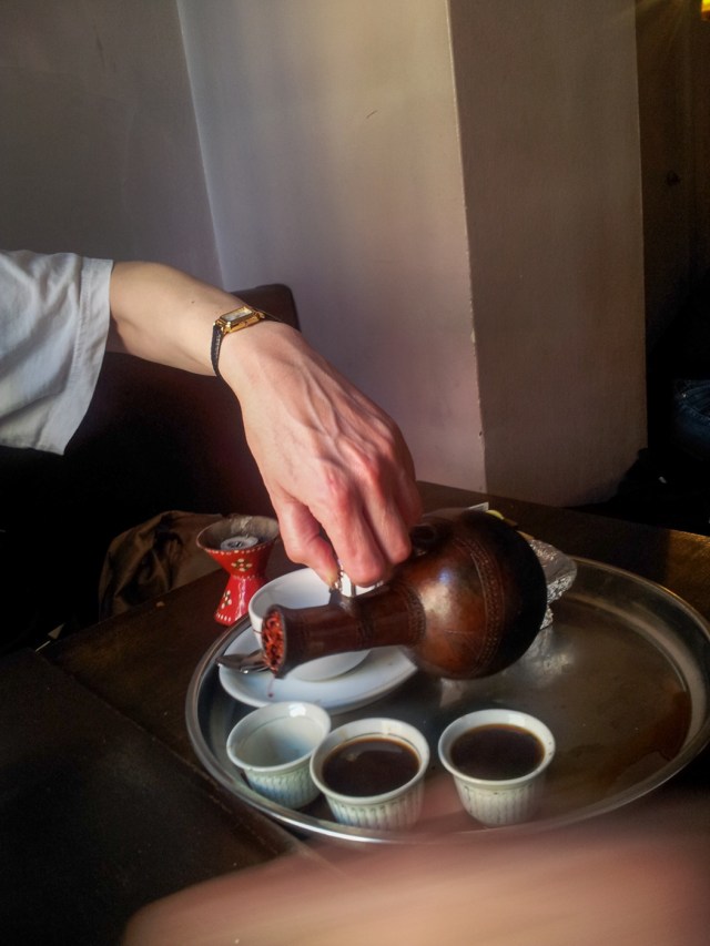 Pouring coffee from traditional Eritrean pot 