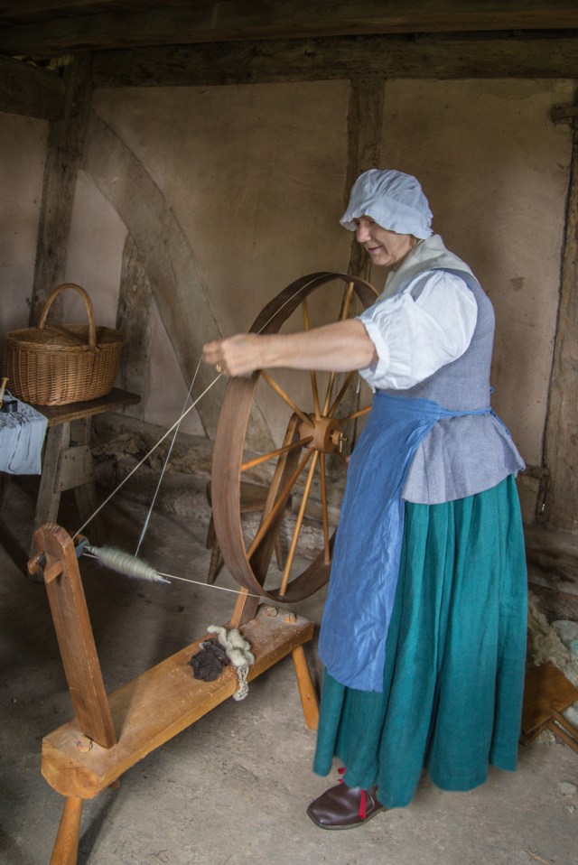 Woman in 18th centry costume at spinning wheel