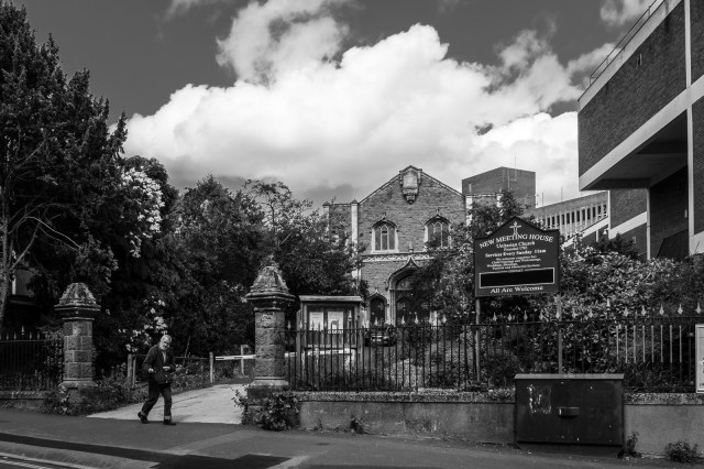 All are Welcome - man walking past church