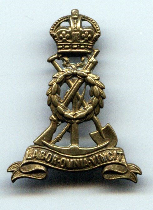 Labour Corps insignia, rifle crossed with space and pickaxe topped with crown. Inscription Labor monia vincit. work conquerss all.